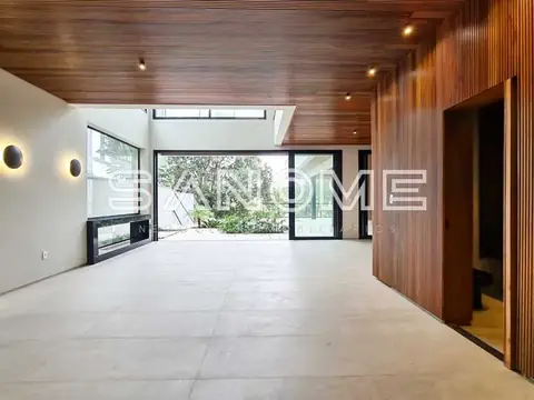 Sala ampla com piso claro e painel de madeira