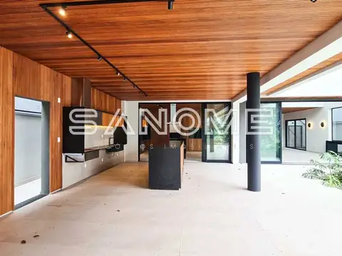 Interior amplo com pilares, piso de concreto e teto em madeira