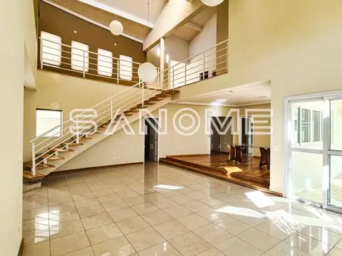 Sala ampla com piso em mármore e escada de madeira