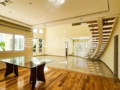 Sala ampla com escada e piso em madeira