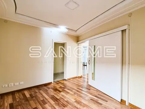 Sala vazia com piso de madeira e paredes bege