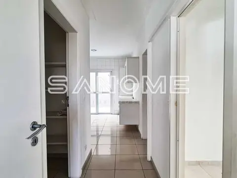 Corredor com porta de entrada e cozinha ao fundo