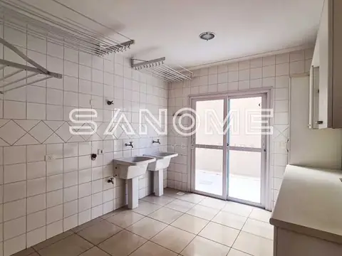 Cozinha com pia, azulejos brancos e porta para área externa