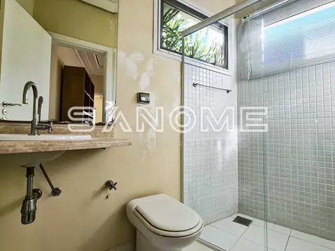 Banheiro com chuveiro box, pia e sanitário
