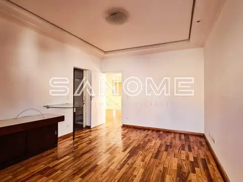Sala vazia com piso de madeira e porta aberta