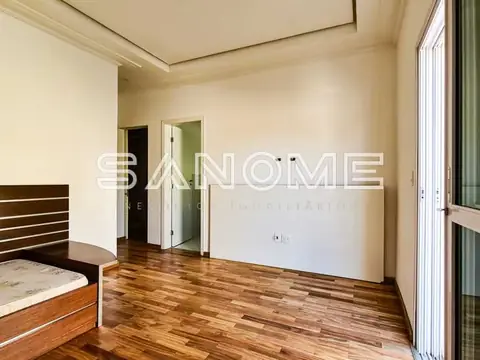 Quarto com cama de madeira e piso em madeira