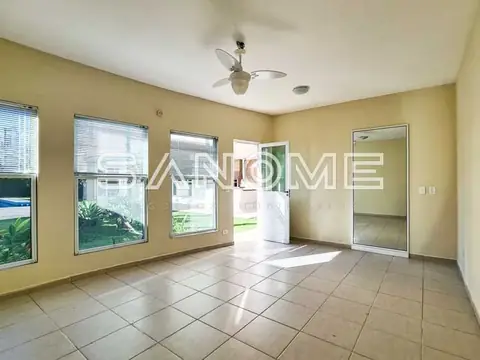 Sala ampla com piso cerâmico e porta para área externa