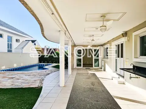 Área externa coberta com piscina ao fundo