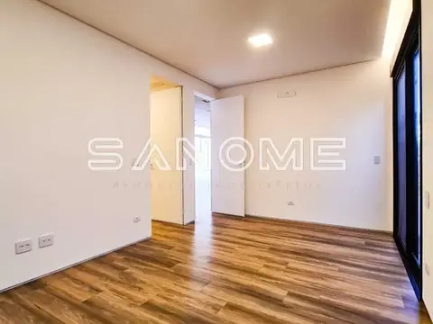 Sala vazia com piso de madeira e portas de acesso