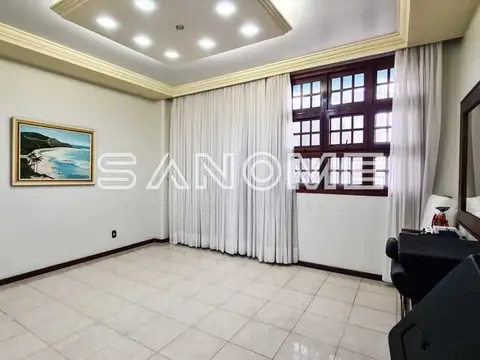 Sala ampla com piso de mármore e cortinas brancas