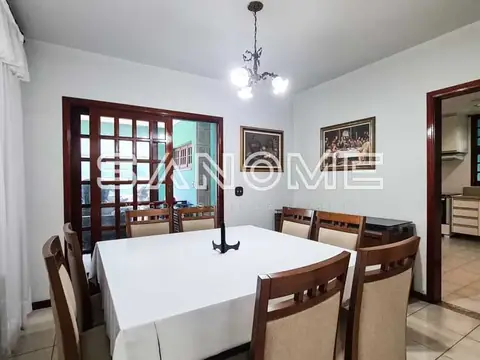 Sala de jantar com mesa branca e cadeiras de madeira