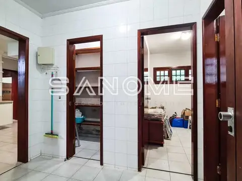 Área de serviço com portas de madeira e azulejos brancos