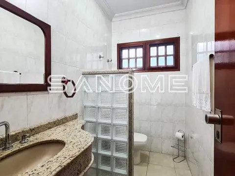 Banheiro com pia, espelho e box com divisória