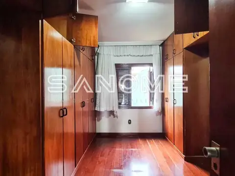 Corredor com guarda-roupas de madeira e piso vermelho