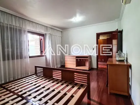 Quarto com móveis de madeira e cortinas brancas