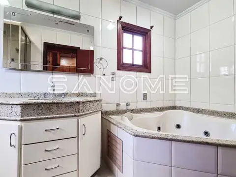 Banheiro com banheira de hidromassagem e pia dupla