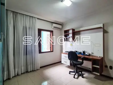 Escritório ou quarto com mesa, cadeira e cortinas
