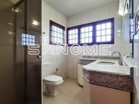 Banheiro com pia em granito e janelas azuis