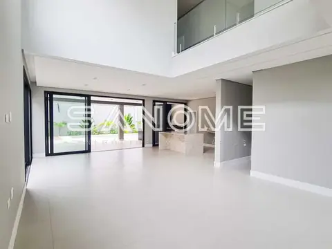 Sala ampla com pé direito duplo e porta de vidro