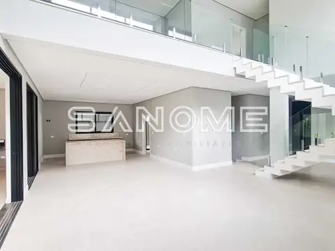 Sala ampla com cozinha integrada e escada