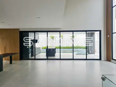 Sala ampla com piso cinzento e portas de vidro para área externa