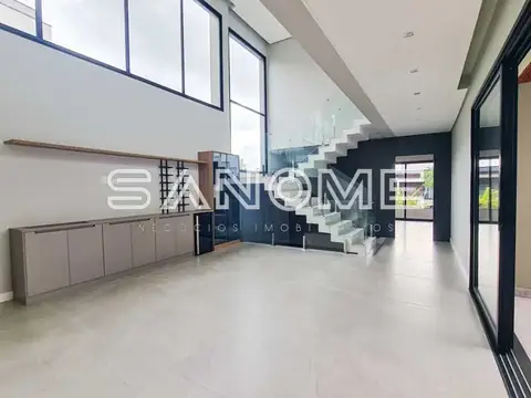 Sala ampla com escada central e pé direito alto