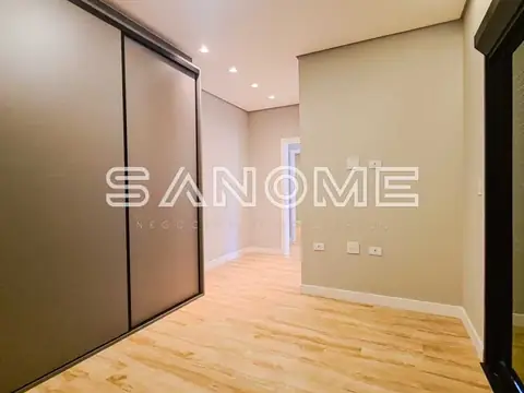 Quarto com guarda-roupa espelhado e piso de madeira