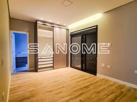 Quarto com guarda-roupa espelhado e porta para banheiro