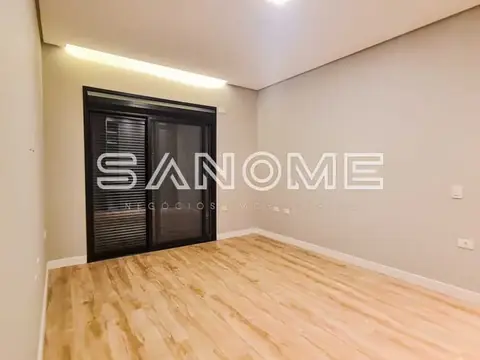 Quarto com piso de madeira e porta de vidro