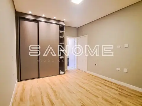 Quarto com guarda-roupa espelhado e piso de madeira