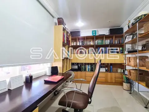 Sala de escritório com mesa, cadeira e estantes de madeira