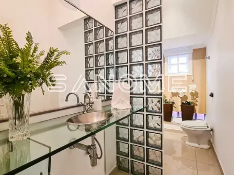 Banheiro com cuba de vidro e painel de azulejos decorativos