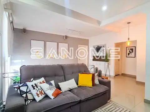 Sala de estar com sofá cinza e painel decorativo
