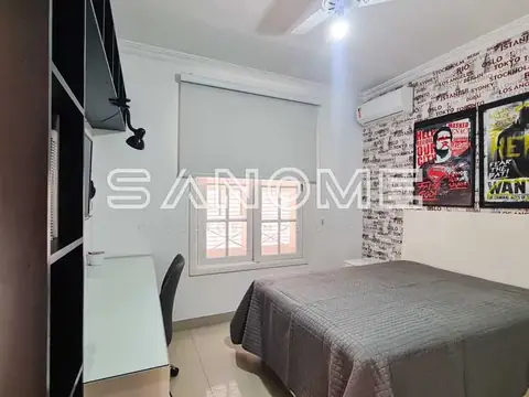 Quarto com cama e parede com pôsteres
