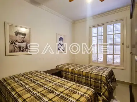 Quarto com duas camas de solteiro e janela
