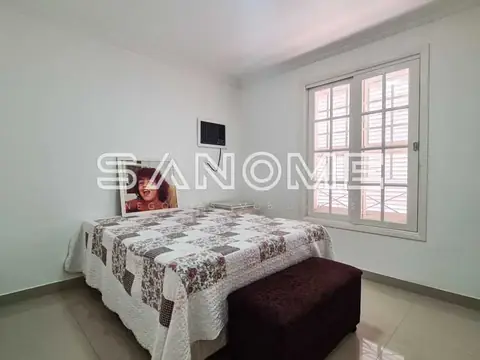 Quarto com cama de casal e porta para varanda