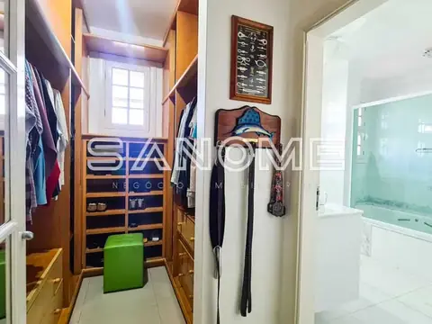 Closet com guarda-roupas e acesso ao banheiro