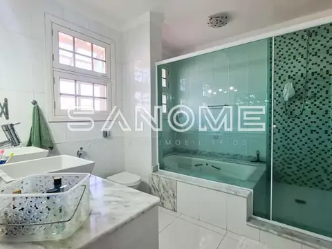 Banheiro com banheira verde e pia de mármore