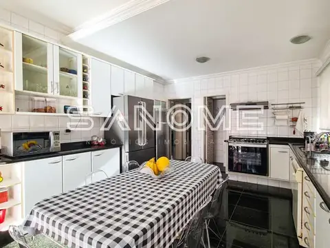 Cozinha planejada com mesa central e eletrodomésticos