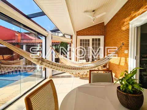 Varanda com rede, mesa redonda e vista para piscina