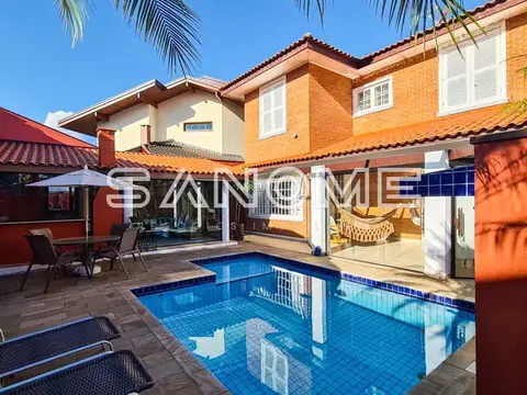 Área externa com piscina e casa de dois andares