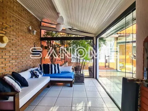 Varanda com sofá, piso cerâmico e vidraças