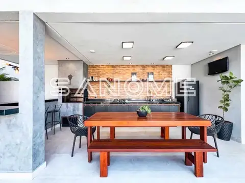 Sala de jantar com mesa de madeira e cozinha ao fundo