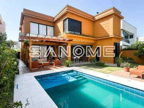 Casa laranja com piscina e área de convivência