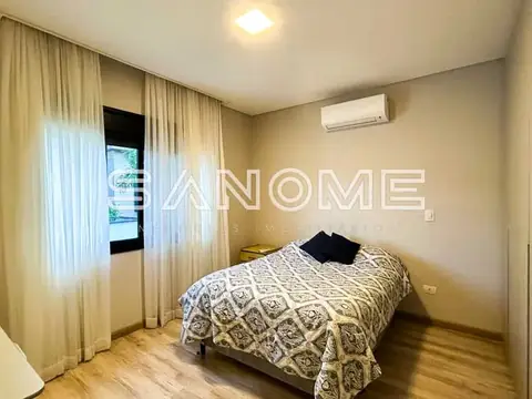 Quarto com cama de casal e cortinas claras