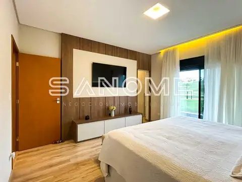 Quarto com cama de casal e painel de madeira