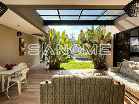 Sala integrada com sofá e vista para área externa com plantas