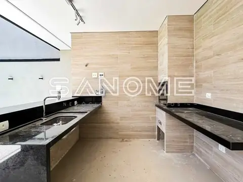 Cozinha com bancadas pretas e parede em madeira