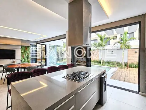 Cozinha integrada com bancada e cooktop, vista para pátio