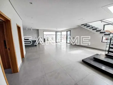 Sala ampla com piso em concreto e escada